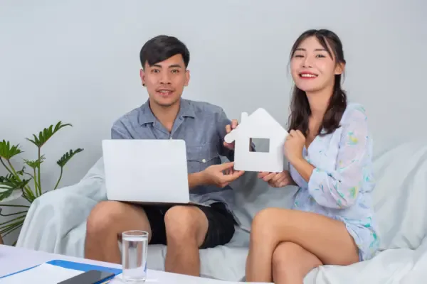 young-couple-is-working-from-home-while-young-girl-is-holding-paper-house-sofa